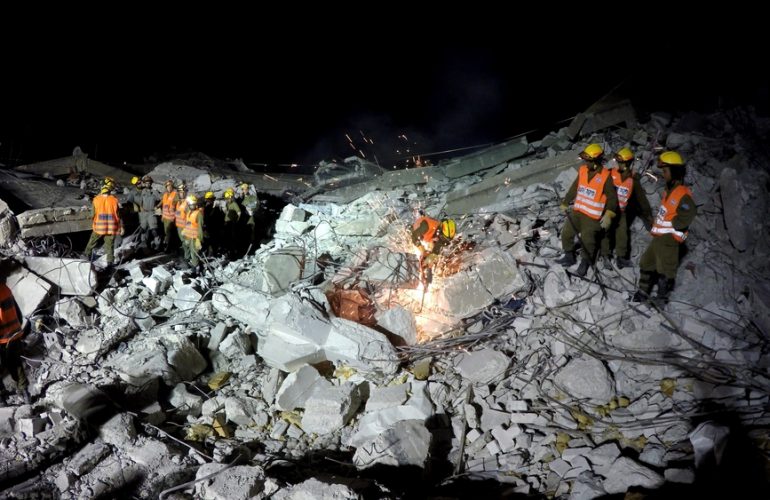 rescuers on earthquake rubble